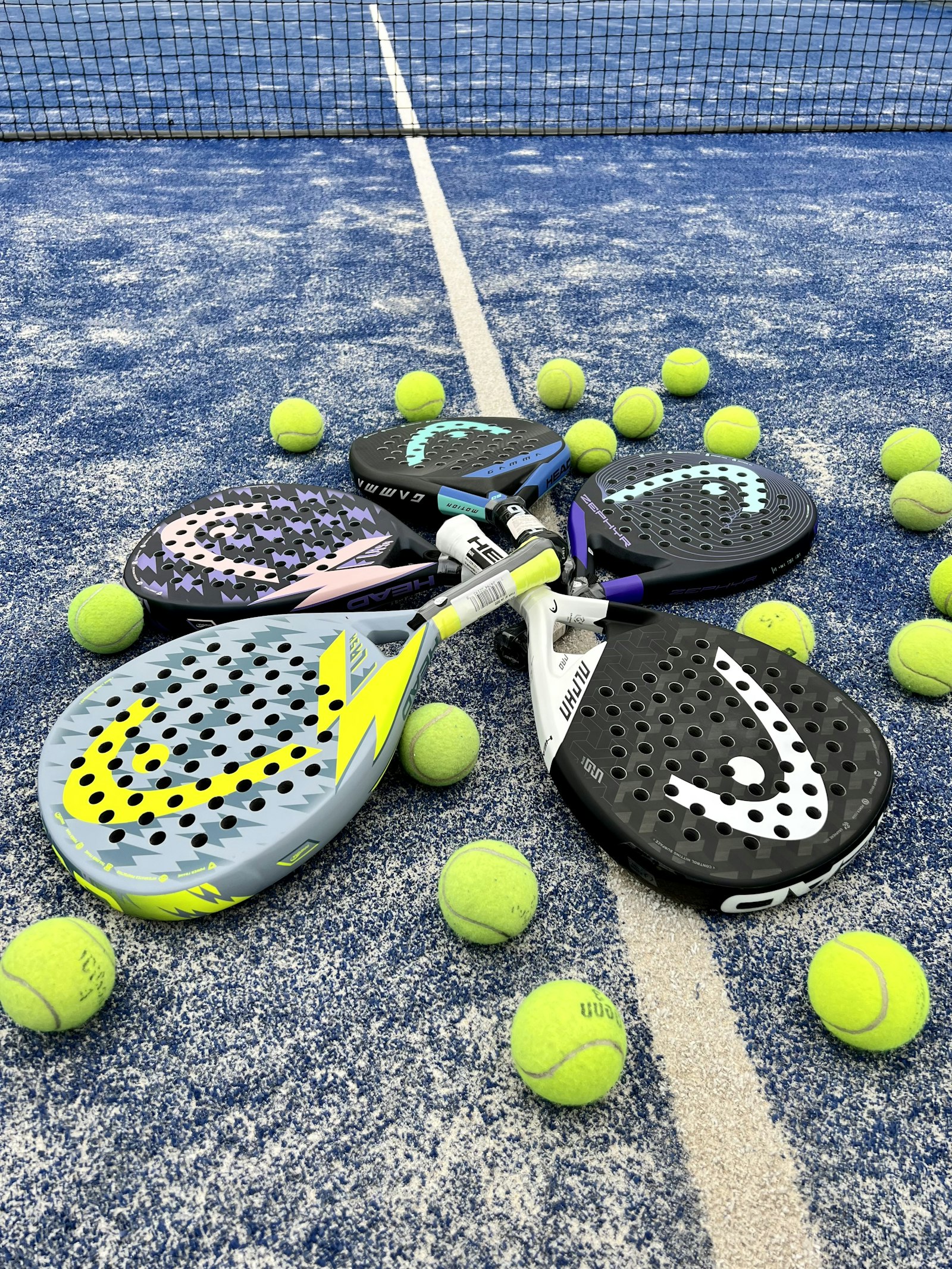 Padel rackets and balls resting on a court
